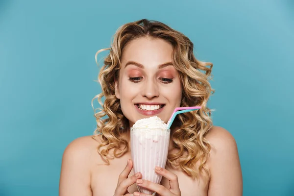 Immagine di adorabile donna mezza nuda con i capelli ricci che sorride alla macchina fotografica mentre tiene il frullato di latte — Foto Stock