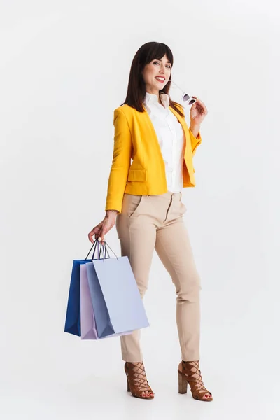 Szép boldog fiatal üzleti nő pózol elszigetelt fehér háttér gazdaság bevásárló táskák. — Stock Fotó