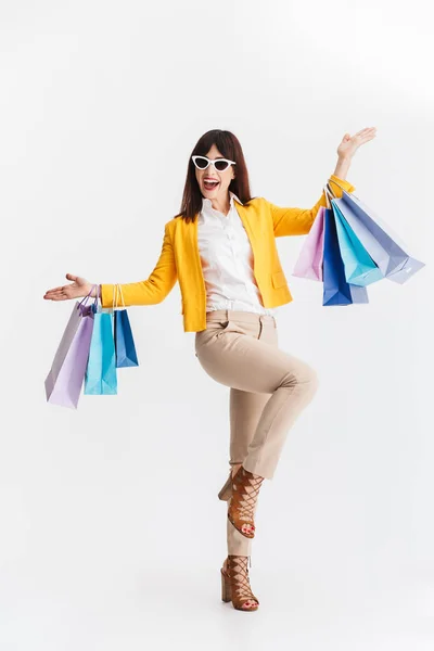 Красива щаслива молода бізнес-леді позує ізольовано на білому тлі тримає сумки для покупок . — стокове фото