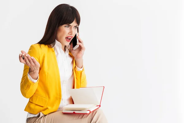 Confuso donna d'affari posa isolato su sfondo bianco parlando da note di scrittura del telefono cellulare . — Foto Stock