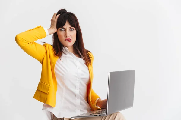 Beautiful young confused business woman posing isolated over white background using laptop computer. — Stock Photo, Image