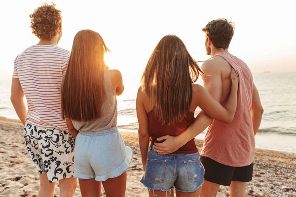 Back View av en grupp människor som står på stranden — Stockfoto