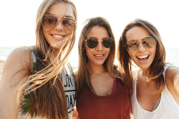 Tres chicas alegres caminando por la playa, divirtiéndose —  Fotos de Stock