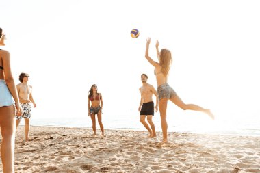 Voleybol oynayan neşeli arkadaşlar grubu