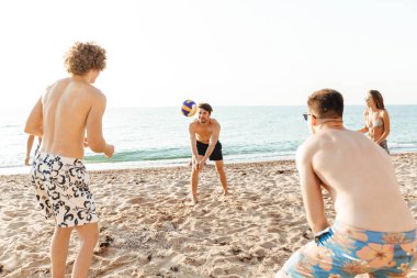 Voleybol oynayan neşeli arkadaşlar grubu
