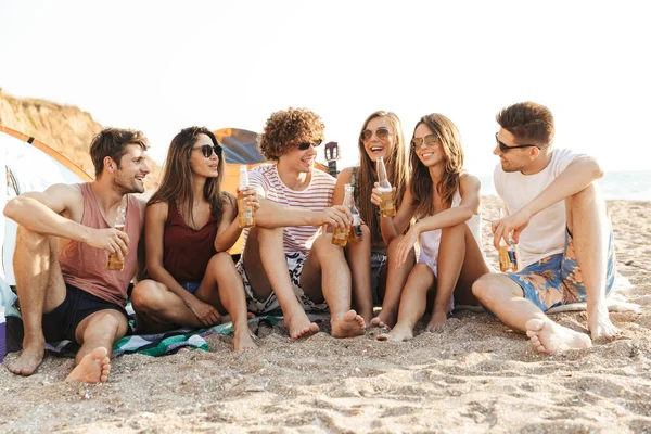 Grupo de alegres amigos felices acampando en la playa — Foto de Stock