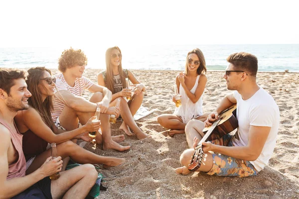 Grupo de alegres amigos felices acampando en la playa — Foto de Stock