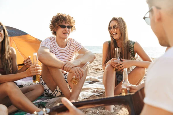 一群欢快的快乐朋友在沙滩上露营 — 图库照片