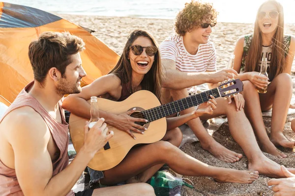 Gruppo di allegri amici felici campeggio in spiaggia — Foto Stock