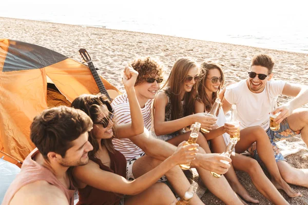 Grupo de alegres amigos felices acampando en la playa — Foto de Stock