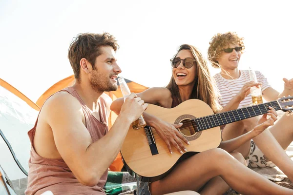 Grupo de alegres amigos felices acampando en la playa — Foto de Stock