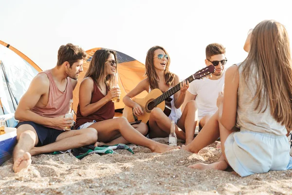 Group of cheerful happy friends camping at the beach — Stock Photo, Image