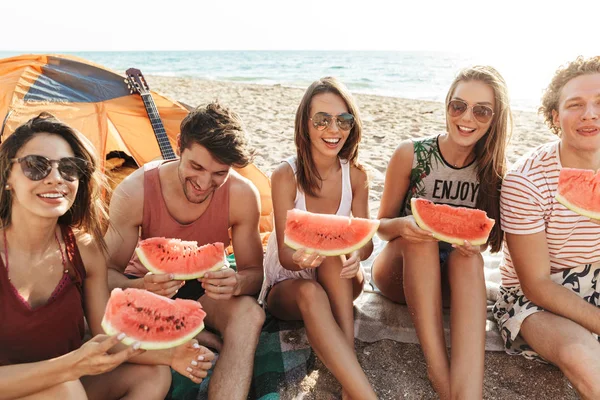 Vrolijke blije vrienden kamperen op het strand — Stockfoto