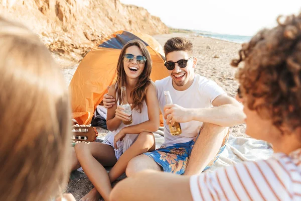 Groupe d'amis joyeux et heureux campant à la plage — Photo