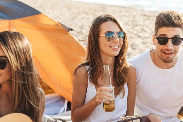 Grupo de alegres amigos felices acampando en la playa — Foto de Stock