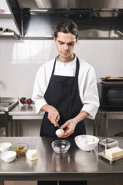 Evde yemek pişiren mutfakta yakışıklı genç aşçı şef. — Stok fotoğraf