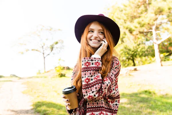 Glücklich erfreut cutie junge Studentin Rotschopf Mädchen im Herbst Park mit Handy. — Stockfoto