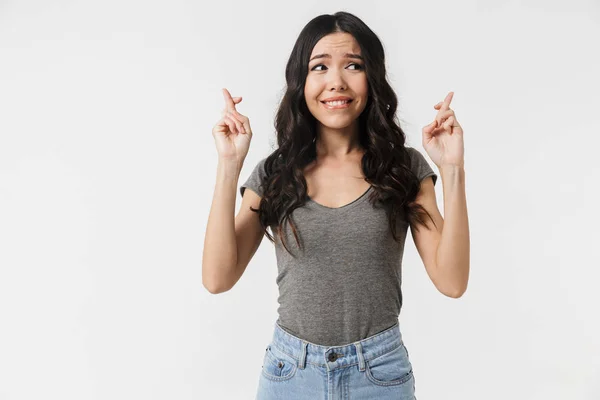 Emotionele jonge vrouw poseren geïsoleerd over witte muur achtergrond maken hoopvolle gelieve gebaar. — Stockfoto