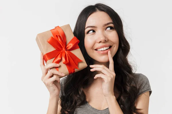 Schöne aufgeregte junge Frau posiert isoliert über weiße Wand Hintergrund hält Geschenk-Box. — Stockfoto