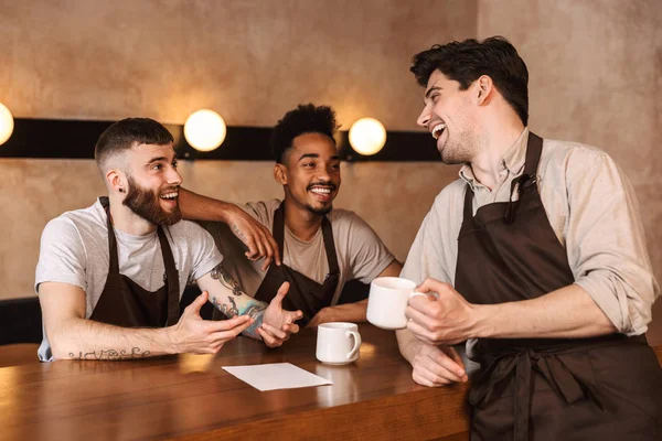 Kahve dükkanında üç neşeli erkek baristas