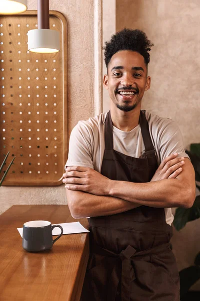 Jovem barista feliz vestindo avental — Fotografia de Stock