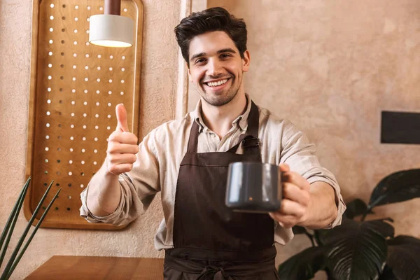 Jovem barista feliz vestindo avental — Fotografia de Stock