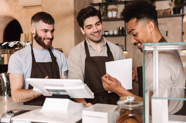 Cübon giyen neşeli erkek baristalar grubu
