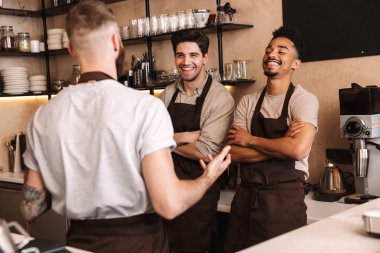 Cübon giyen neşeli erkek baristalar grubu