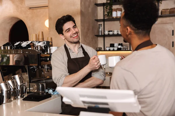 Happy coffee men colleagues in cafe bar working indoors.