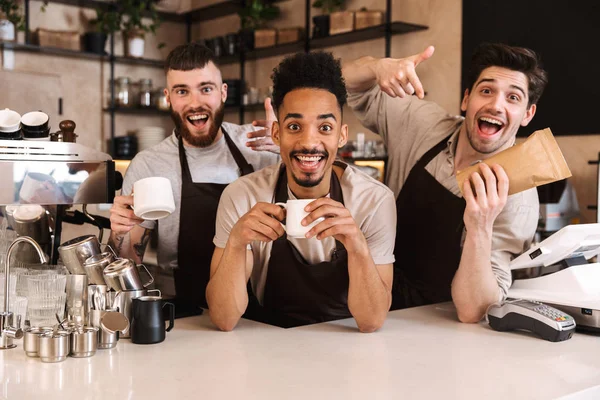 Grupo de homens alegres baristas vestindo aventais — Fotografia de Stock