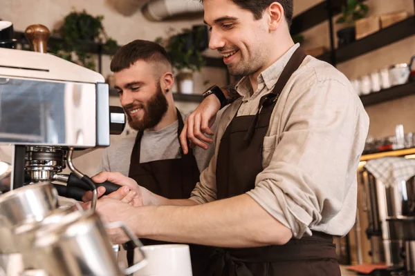 Group of cheerful men baristas wearing aprons — Stock Photo, Image