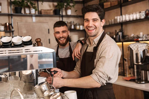 Group of cheerful men baristas wearing aprons — Stock Photo, Image