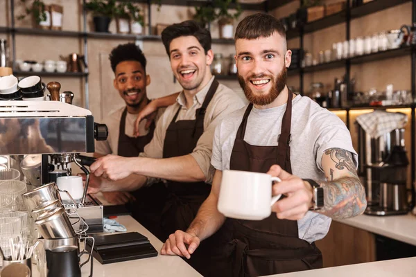 Trois baristas masculins joyeux debout au café — Photo