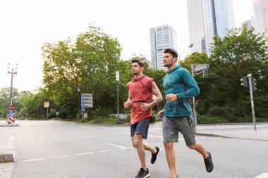 İki atletik yakışıklı erkek egzersiz yapıyor ve şehir sokakta çalışan fotoğraf