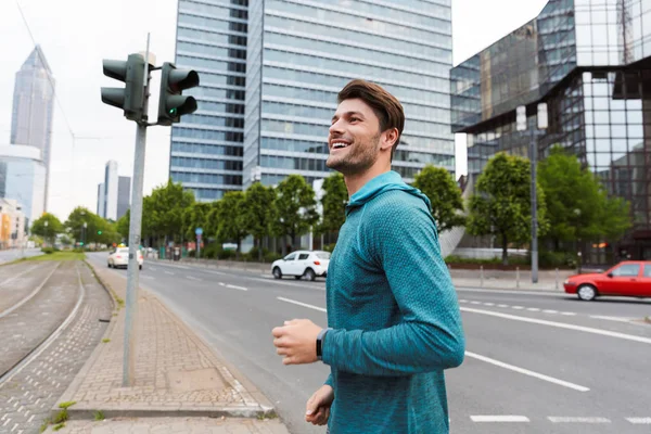 Foto av atletisk stilig man gör träning och kör på City Street — Stockfoto