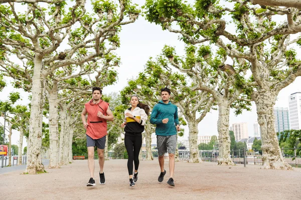 Foto av sportiga unga människor som tränar och springer i stadsparken — Stockfoto