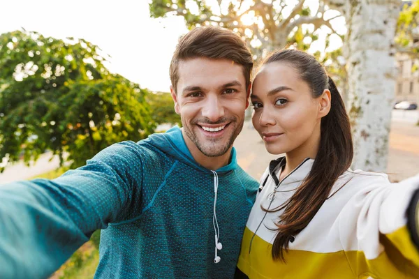 Foto di uomo e donna felice sorridente scattare foto selfie mentre si lavora in viale della città — Foto Stock