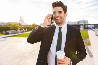 Ayakta takım elbise giyen çekici genç işadamı