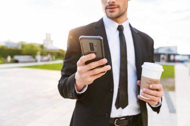 Ayakta takım elbise giyen çekici genç işadamı