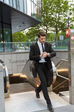 Çekici genç işadamı yürüyüş takım elbise giyiyor