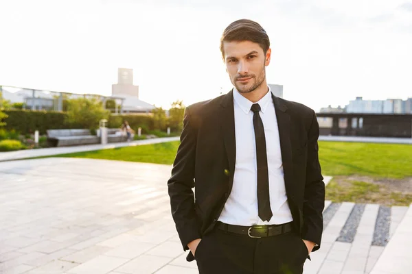 Bello giovane uomo d'affari che indossa vestito camminare all'aperto — Foto Stock