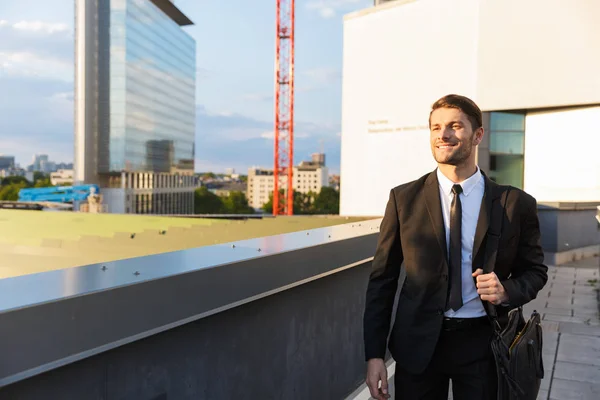 Bonito jovem empresário vestindo terno andando ao ar livre — Fotografia de Stock