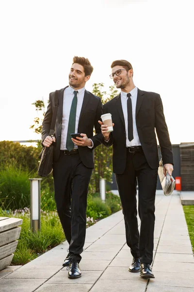 Twee aantrekkelijke jonge zakenlui die kostuums dragen — Stockfoto