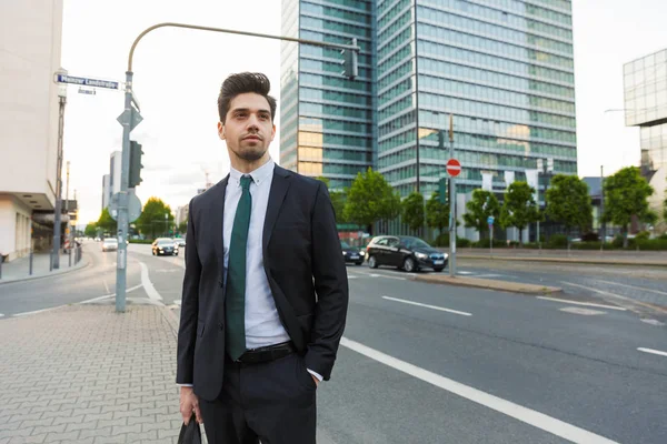 Bonito jovem empresário vestindo terno andando ao ar livre — Fotografia de Stock