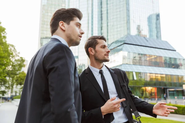 Takım elbise giyen iki çekici genç işadamı