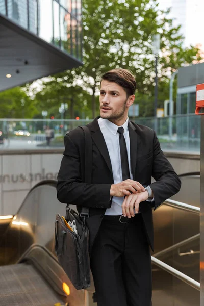 Atractivo joven hombre de negocios usando traje caminando —  Fotos de Stock