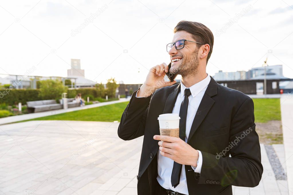 Attractive young businessman wearing suit standing