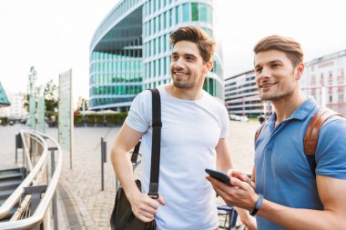 İki gülümseyen genç erkek arkadaşlar rahat giyinmiş