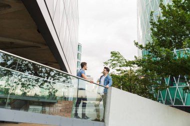 İki gülümseyen genç erkek arkadaşlar rahat giyinmiş