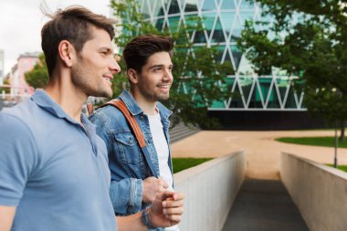 İki gülümseyen genç erkek arkadaşlar rahat giyinmiş